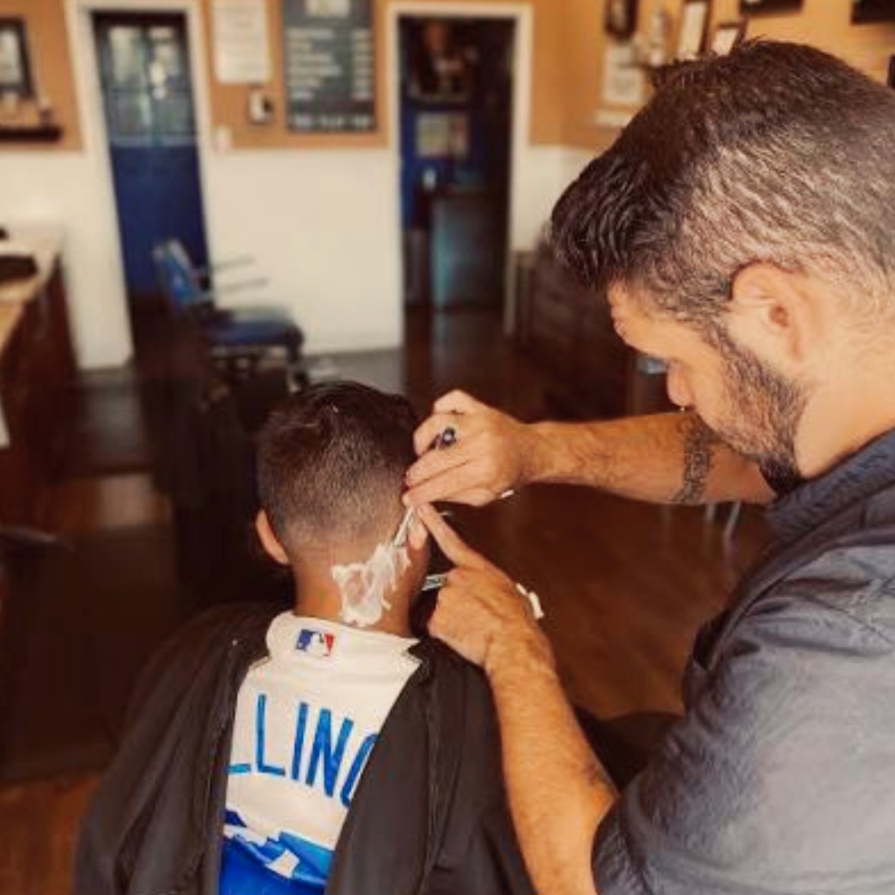 Barber giving a haircut inside The Flat Top